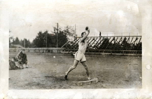 Black and white photo of an unidentified University of Oregon shot putter in action during a 1913 practice at Kincaid Field. 